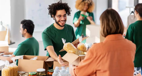 Freiwillige Helfer verpacken Lebensmittelspenden in Organisationsteam.