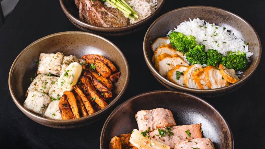 Vier proteinreiche Bowls mit Fleisch, Gemüse und Reis.
