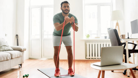 Man using resistance band for home workout.