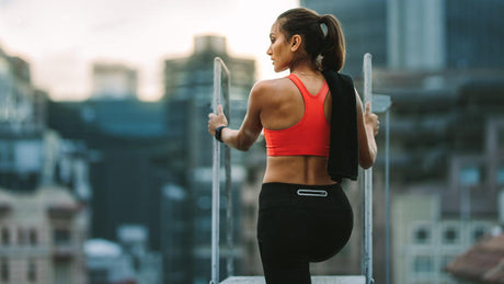 Femme en tenue de sport se reposant sur un toit urbain.