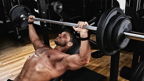 Man doing bench press in gym.