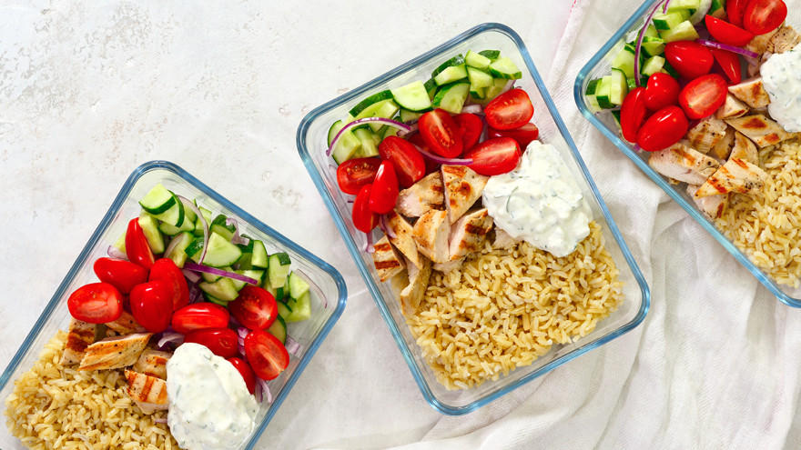 Meal Prep mit Hähnchen, Reis, Tomaten, Gurke und Tzatziki.