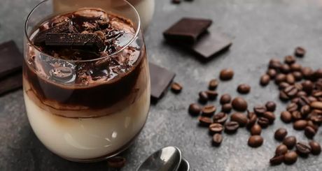 Chocolate coffee dessert in glass with beans and chocolate chunks.