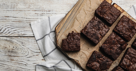 Chocolade brownies op houten plank met bakpapier.