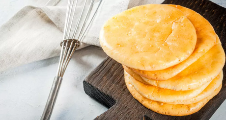 Stapel proteinreicher Pfannkuchen auf Holzbrett.