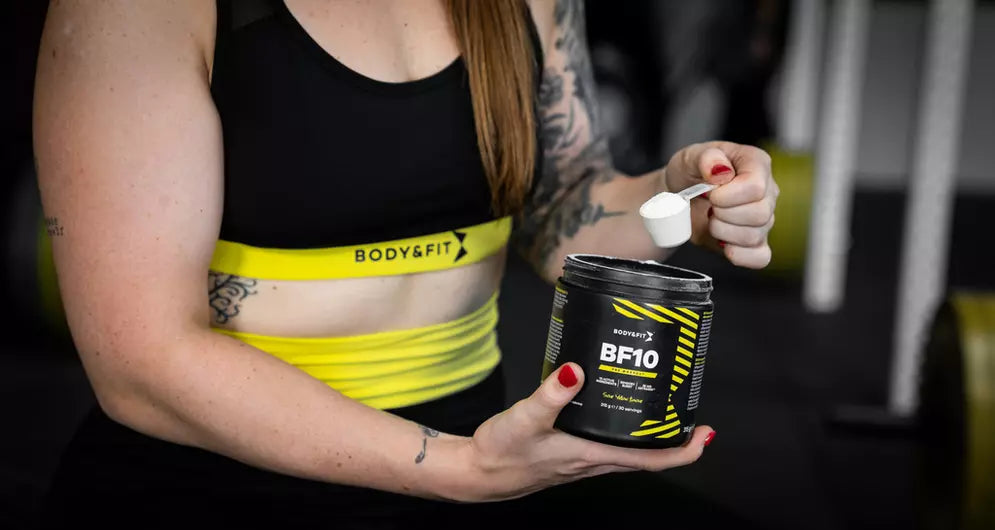 Femme dosant du BF10 Body&Fit en salle de sport.
