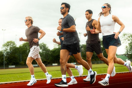 Group of runners training together on an outdoor athletics track