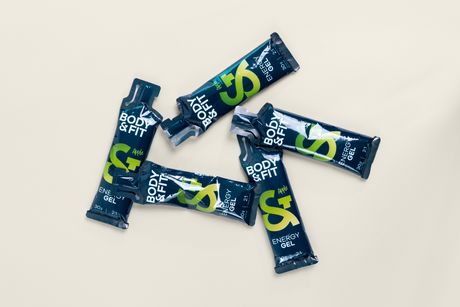 Four Body&Fit Energy Gel sachets in Apple flavour, showing the 30g carbohydrate content and 2:1 glucose-to-fructose ratio on the packaging.