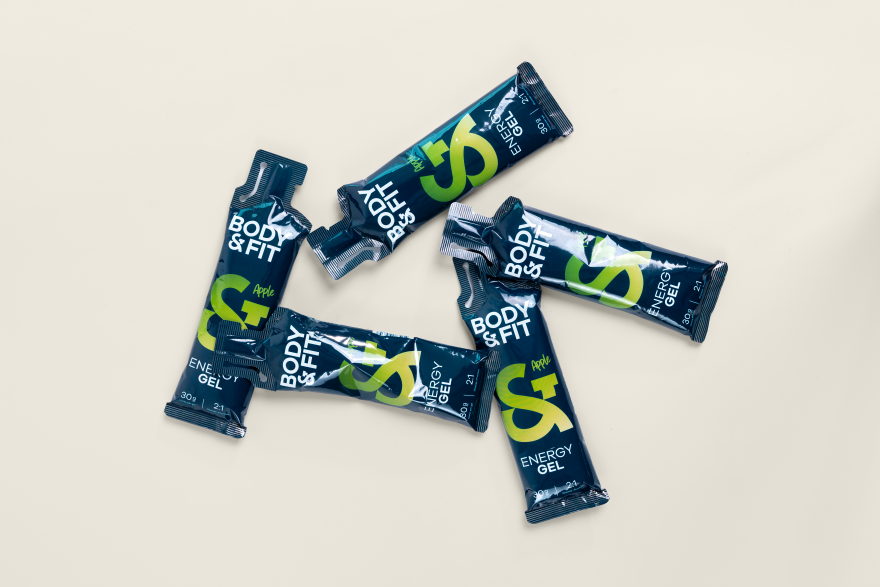 Vier Body&Fit Energy Gel-sachets in de smaak Apple, met op de verpakking 30g koolhydraten en de 2:1-verhouding glucose op fructose.