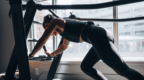 Woman doing incline cardio workout on curved treadmill in gym.