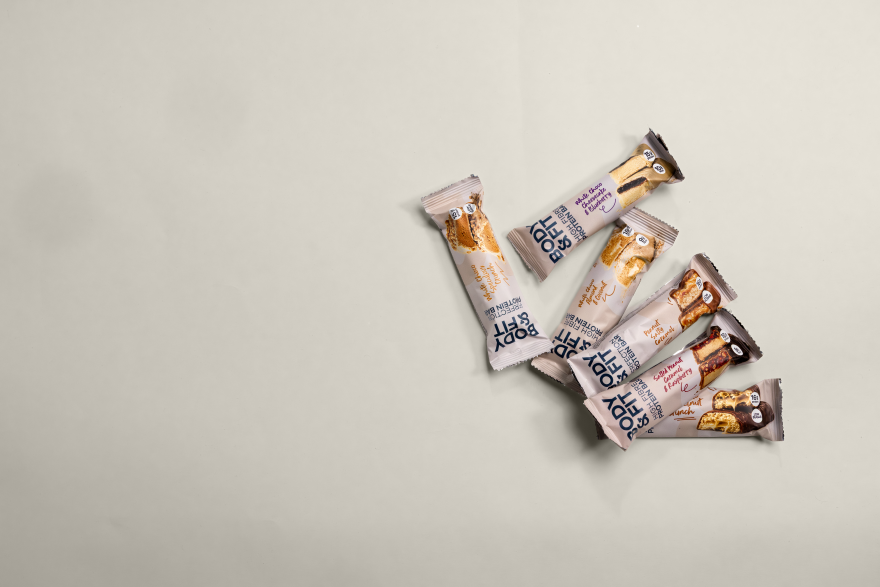 Verpakkingen van de Body&Fit High Fibre Protein Bar in de smaken Salted Peanut Caramel & Raspberry, White Chocolate Almond & Coconut en White Chocolate Blueberry Cheesecake