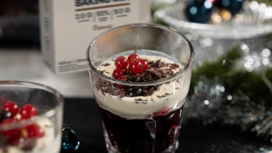 Dessert in glas met rood fruit en chocoladeschilfers.