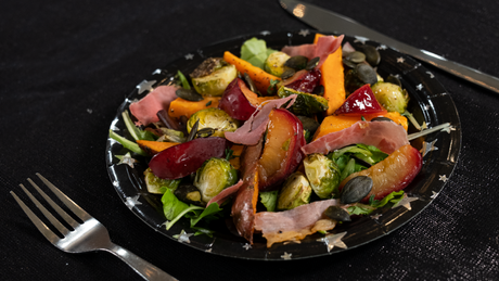 Salade met spruitjes, pruimen, pompoen en ham.