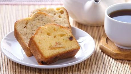 Sliced cake and cup of tea on mat.