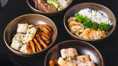 Vier proteinreiche Bowls mit Fleisch, Gemüse und Reis.