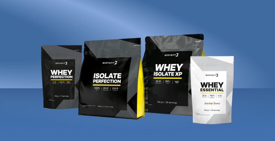 Selection of Body&Fit protein powders including whey, isolate and essential blends displayed in packaging on a blue background