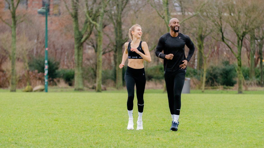 Couple en tenue de sport courant dans un parc.