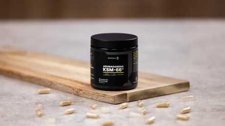 Ashwagandha supplement capsules with black Body&Fit jar on board.