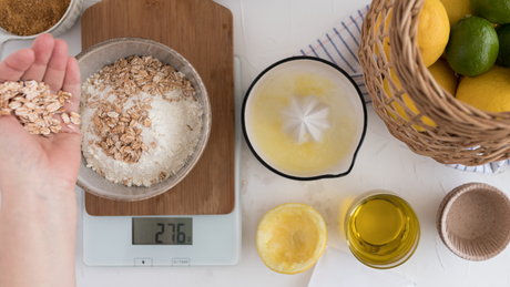Ingrediënten op weegschaal voor gezond bakrecept met havermout en citroen.