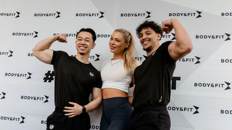 Three fit people posing at Body&Fit branded event backdrop.