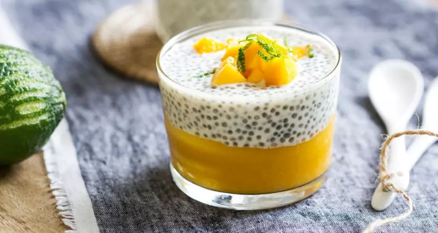 Pudding chia protéiné sur purée de mangue, garni de dés de mangue et de zeste de citron vert