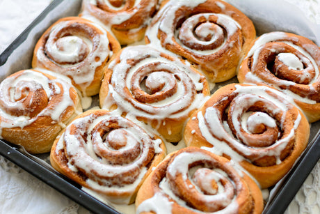 Brioches à la cannelle fraîchement sorties du four avec glaçage dans un plat de cuisson