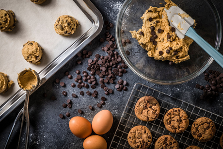 Protein Chocolate Chip Cookies backen: Teigkugeln auf dem Backblech, Keksteig mit Schokotropfen in einer Schüssel und gebackene Cookies auf einem Gitter