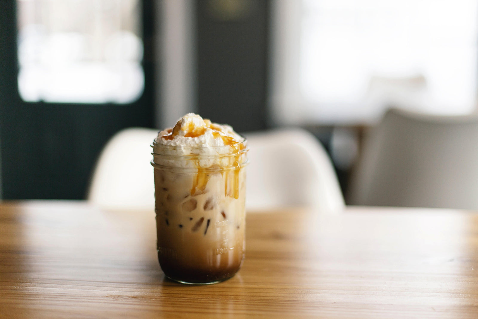 Café glacé au caramel avec chantilly dans un verre mason.
