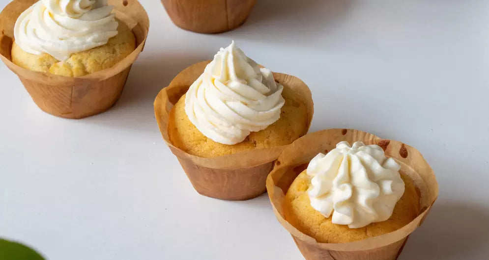 Vanilla cupcakes topped with fluffy white cream frosting.
