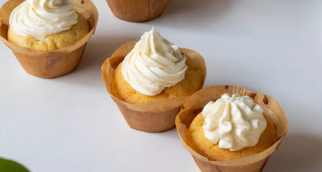 Vanilla cupcakes topped with fluffy white cream frosting.