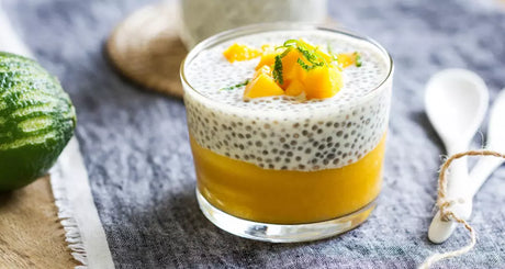 Chia-Pudding mit Mango-Schicht und frischen Früchten im Glas.