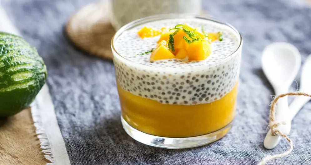 Chia pudding met mango en munt in glazen schaaltje.