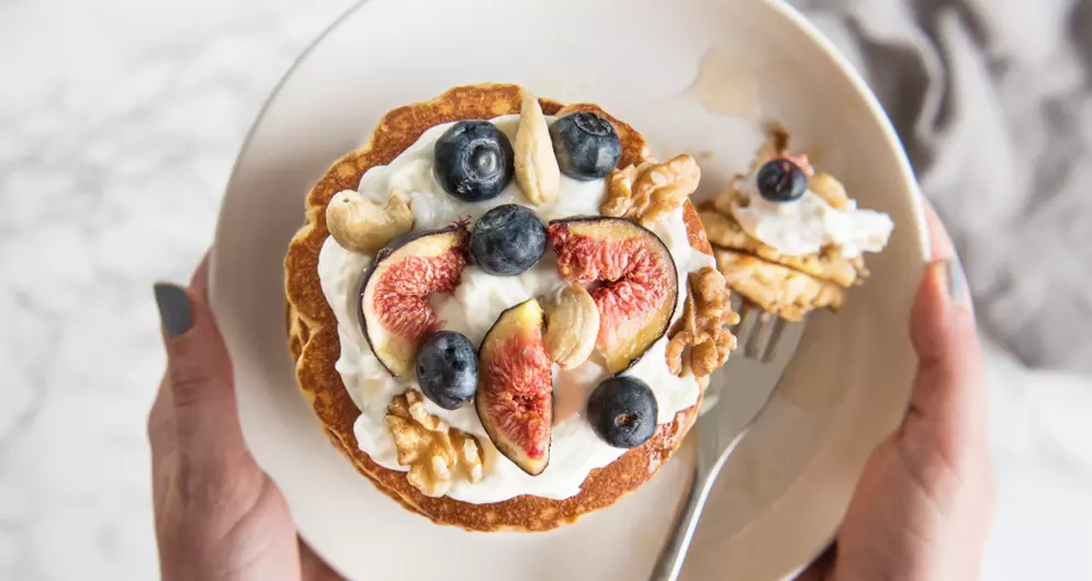 Protein pancakes topped with figs, blueberries, and nuts.