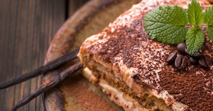 Tiramisu saupoudré de cacao et décoré de menthe.