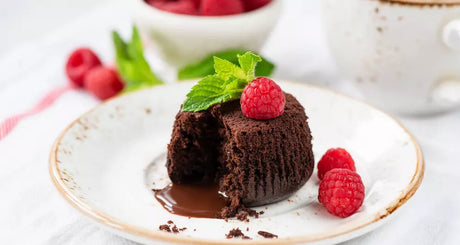 Lava cake met gesmolten chocolade en frambozen op bord.