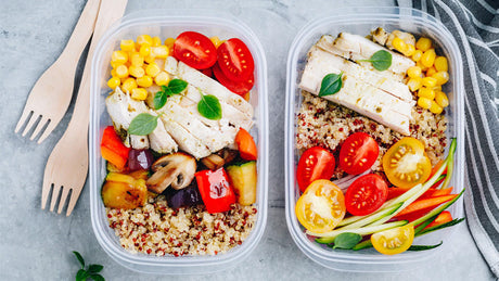 Two healthy meal prep boxes with grilled chicken, quinoa, and vegetables.