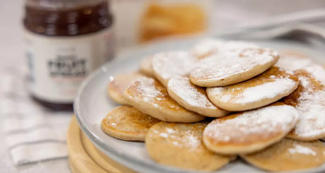 Stapel mini pancakes met poedersuiker.