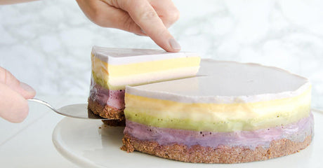 Laagjestaart in regenboogkleuren met koekbodem.