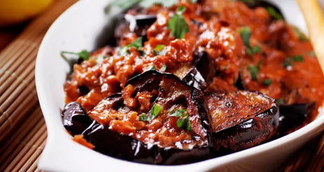 Ovenschotel met aubergine en kruidige tomatensaus.