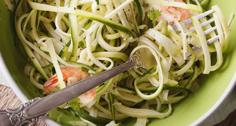 Courgette-noedels met garnalen in groene kom.