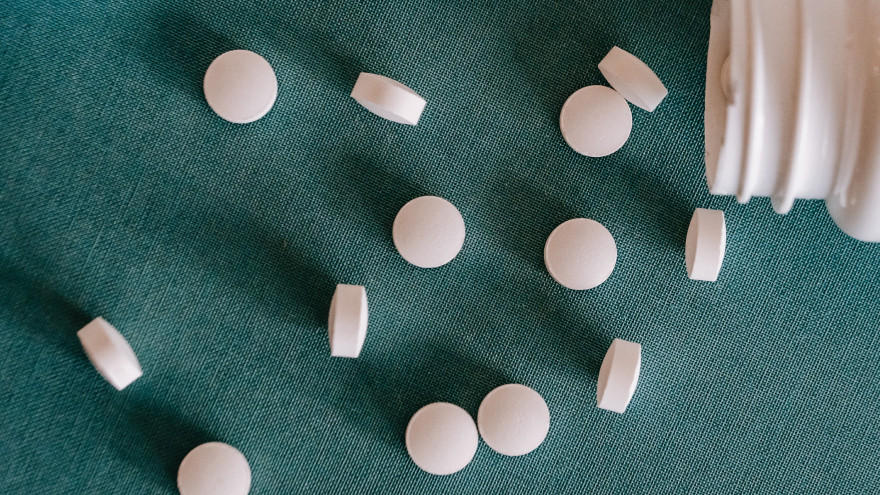 Witte tabletten verspreid over een groen oppervlak.