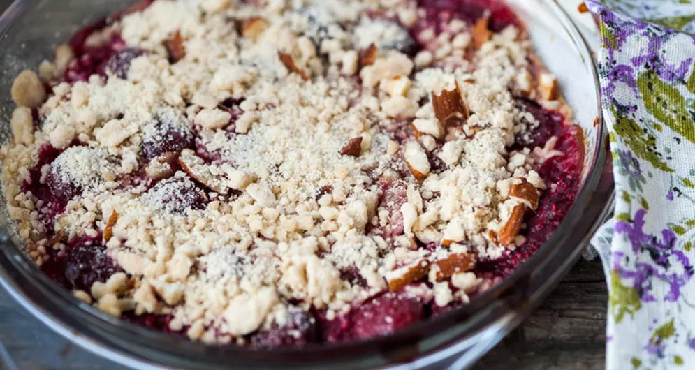 Fruchtiger Crumble mit Beeren und Streuseln in runder Glasform.