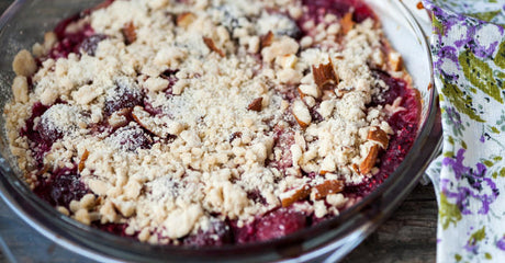 Kersencrumble met amandelkruimels in ovenschaal.